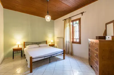 a bedroom with a bed and a dresser and a window at Femina in Pírgos Psilonérou
