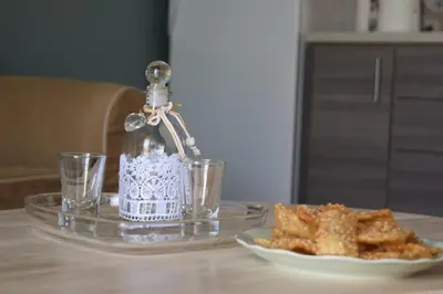 a glass table with a bottle and a plate of food at Sofia's view Kissamos in Kissamos