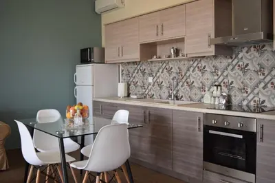 a kitchen with a table and white chairs at Sofia's view Kissamos in Kissamos