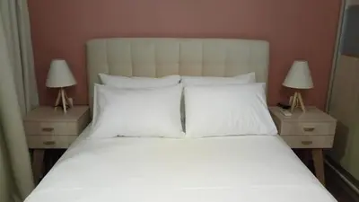 a bed with white sheets and pillows and two lamps at Sofia's view Kissamos in Kissamos