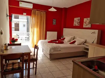 a bedroom with red walls and a bed and a table at Steps From The Beach Aprt in Chania Town