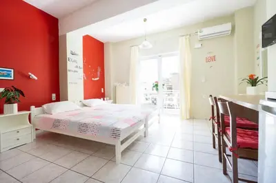 a bedroom with a bed and a red wall at Steps From The Beach Aprt in Chania Town
