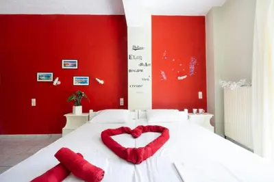 a bed with two red pillows in the shape of a heart at Steps From The Beach Aprt in Chania Town