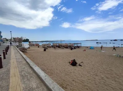 a beach with people on the sand and the water at Steps From The Beach Aprt in Chania Town