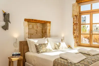 a bedroom with a large bed with a window at Aelios Design Hotel in Chania Town