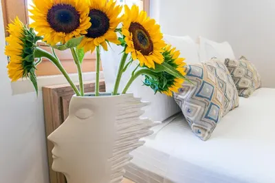 a vase filled with sunflowers sitting on a bed at Aelios Design Hotel in Chania Town