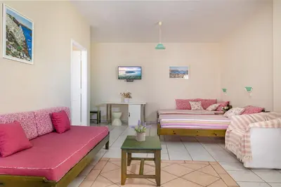 a living room with two couches and a table at Armonia Apartments in Almirida