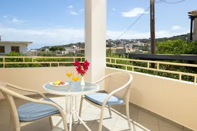 a table and chairs on a balcony with a view at Armonia Apartments in Almirida