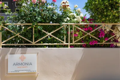 a book sitting on a bench in front of flowers at Armonia Apartments in Almirida