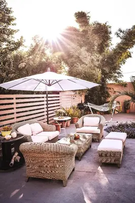 a patio with wicker furniture and an umbrella at Villa Avly in Maleme