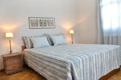 a bedroom with a bed with a blue and white blanket at Villa Avly in Maleme