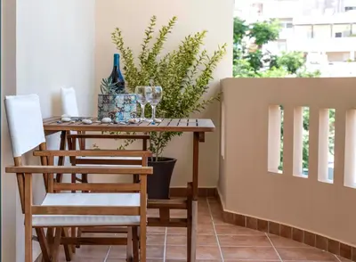 a table with two chairs and wine glasses on a balcony at Plumi City Apartments in Chania Town