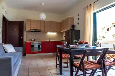 a kitchen and living room with a table and chairs at Plumi City Apartments in Chania Town
