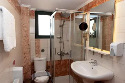 a bathroom with a toilet and a sink and a shower at Plumi City Apartments in Chania Town