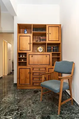 a room with a wooden cabinet and a chair at Evridiki's House Central Chania in Chania Town