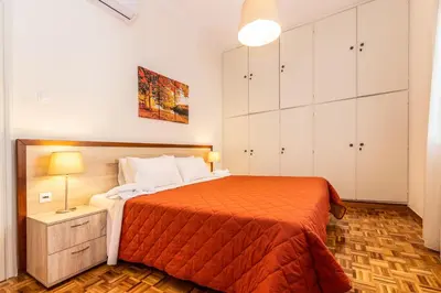 a bedroom with a large bed with an orange bedspread at Evridiki's House Central Chania in Chania Town