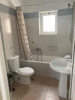 a bathroom with a toilet and a tub and a sink at Poseidon Studios & Apartments in Palaiochóra