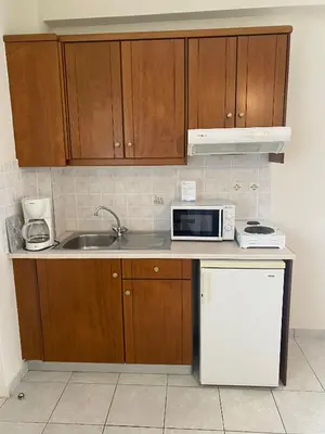 a kitchen with a sink and a microwave at Poseidon Studios & Apartments in Palaiochóra