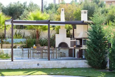 a house with an outdoor kitchen and a patio at Villa Thalia in Stalos