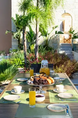 a table with a plate of food and orange juice at Villa Thalia in Stalos