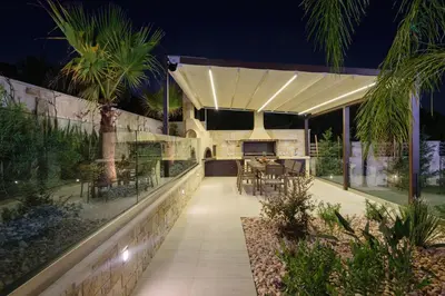 an outdoor kitchen and dining area of a house at night at Villa Thalia in Stalos