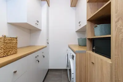 a small kitchen with white cabinets and a television at Villa Thalia in Stalos