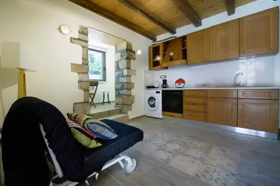 a kitchen with a chair in the middle of a room at Kyriaki's Traditional House in Galatás
