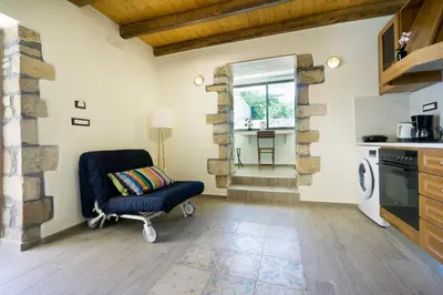a room with a chair in a kitchen with a window at Kyriaki's Traditional House in Galatás