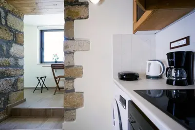 a kitchen with white counters and a brick wall at Kyriaki's Traditional House in Galatás