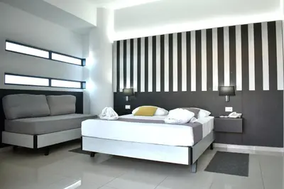 a bedroom with a white bed and a couch at Galini Sea View in Agia Marina Nea Kydonias
