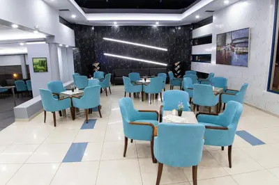a dining room with blue chairs and tables at Galini Sea View in Agia Marina Nea Kydonias