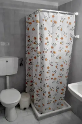 a bathroom with a toilet and a shower curtain with butterflies at Katerina Palaiochora in Palaiochóra