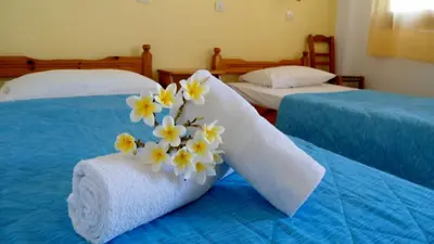 two beds with towels and flowers on them at Katerina Palaiochora in Palaiochóra