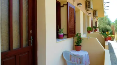 a house with a table and a chair next to a door at Katerina Palaiochora in Palaiochóra