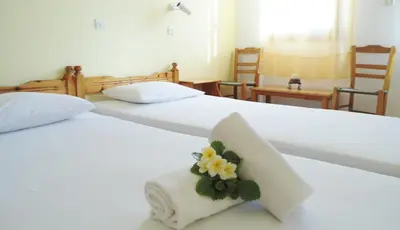 two beds with towels and a flower on them at Katerina Palaiochora in Palaiochóra