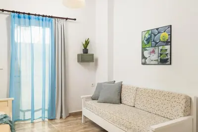 a living room with a couch and a window at Dimitra & Evdokia Hotel in Agia Marina Nea Kydonias