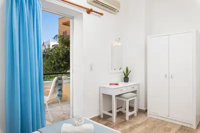 a white room with a desk and a mirror at Dimitra & Evdokia Hotel in Agia Marina Nea Kydonias