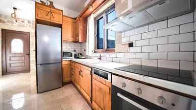 a kitchen with wooden cabinets and a stainless steel refrigerator at Estia in Plátanos