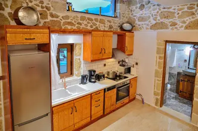 a kitchen with wooden cabinets and a stainless steel refrigerator at Nemesis in Plátanos