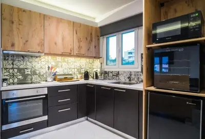a kitchen with wooden cabinets and a sink and a microwave at Talos Luxury Suites in Kounoupidhianá