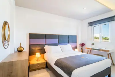 a bedroom with a large bed and a desk at Talos Luxury Suites in Kounoupidhianá