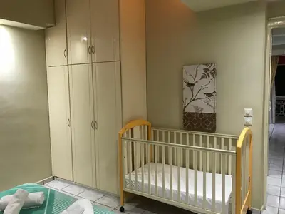 a baby room with a crib and some cabinets at Steps to Nea Chora beach Angela apt ,10min to town in Chania Town