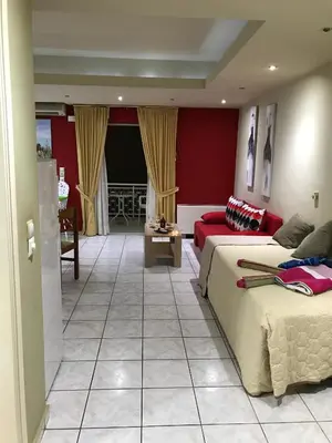 a bedroom with two beds and a red wall at Steps to Nea Chora beach Angela apt ,10min to town in Chania Town
