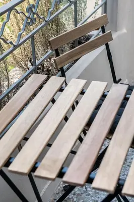 a wooden bench sitting next to a metal fence at Artemide city places-Splantzia Square in Chania Town