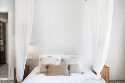 a bedroom with a white bed with white curtains at Artemide city places-Splantzia Square in Chania Town