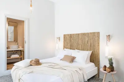 a white bedroom with a white bed and a mirror at Artemide city places-Splantzia Square in Chania Town