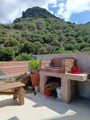 a brick oven on a roof with a mountain in the background at Dream House in Perivólia