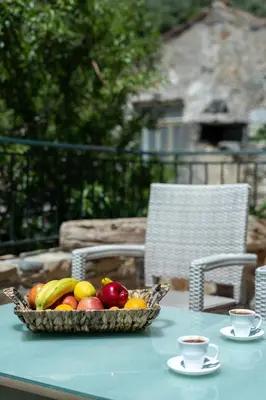 a bowl of fruit on a table with two cups of coffee at Dream House in Perivólia
