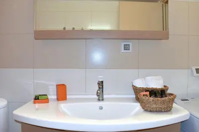 a bathroom sink with a mirror and a basket on it at Modi Home in Vrísai