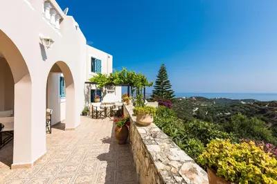 a balcony of a house with a view of the ocean at Villa Ariadne in Stalos
